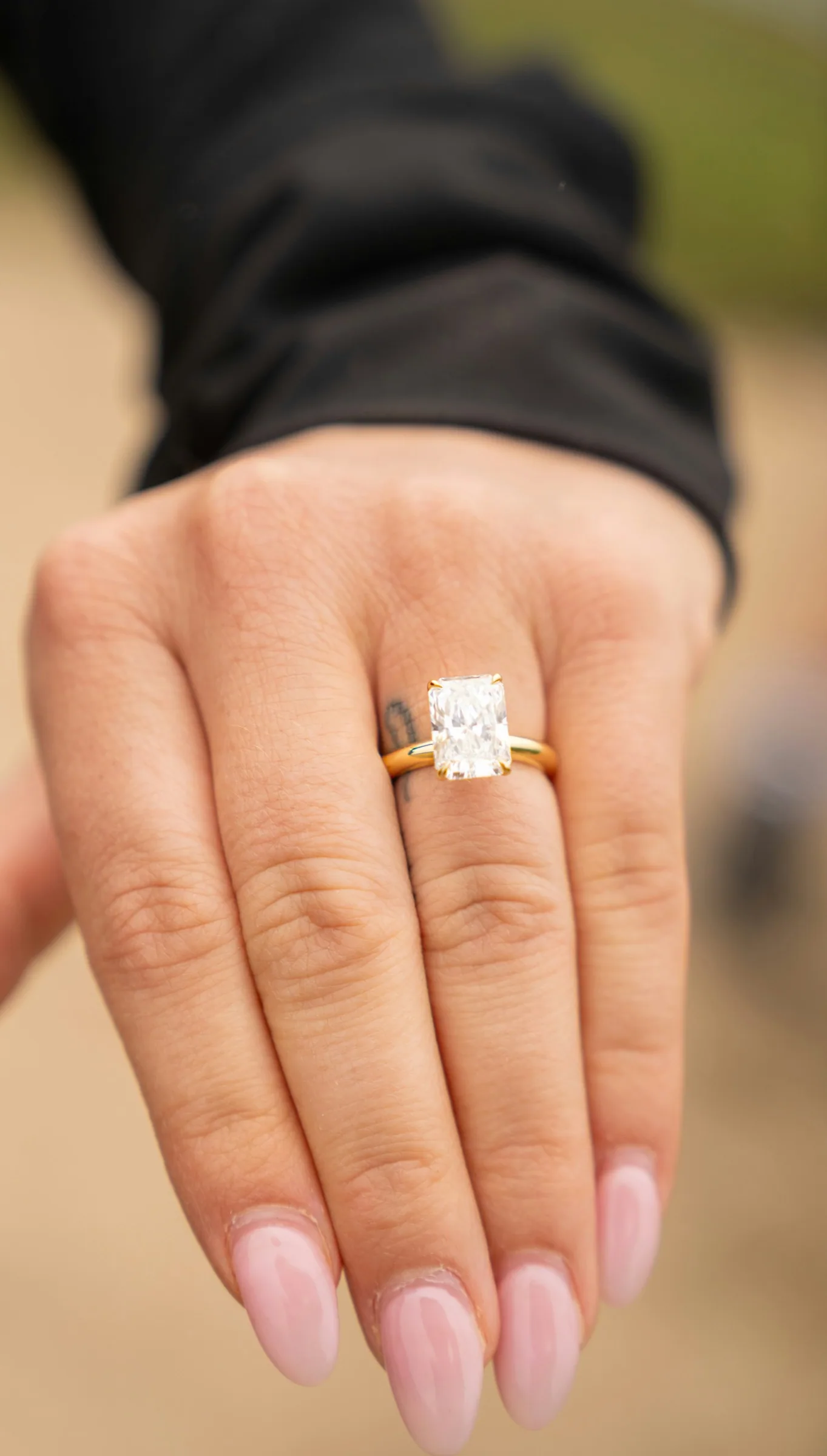 An outstretched hand wearing a radiant-cut diamond solitaire