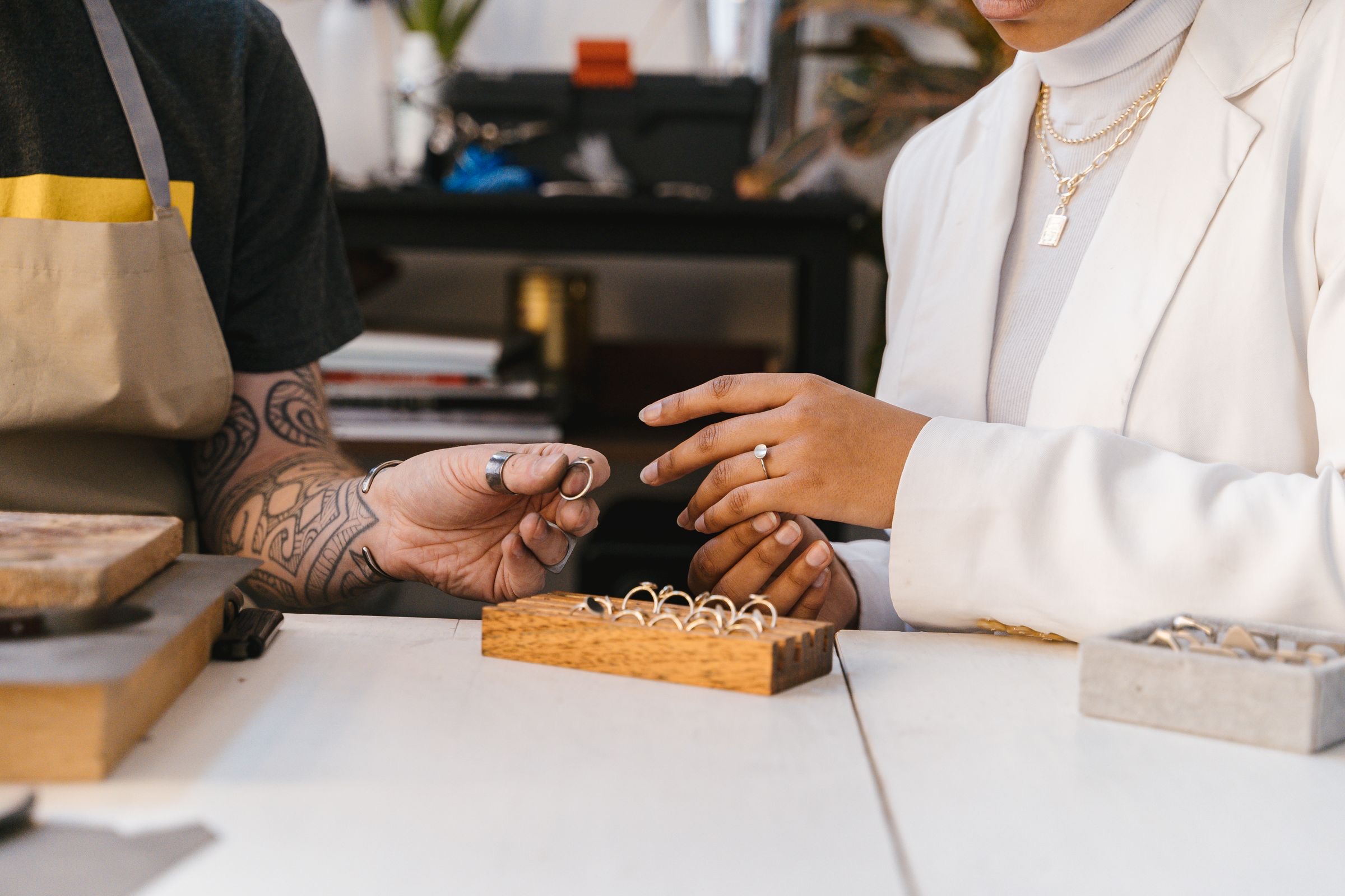 A jeweler showing rings to a client across a studio table
